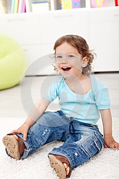 Happy toddler boy sitting on the floor