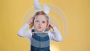 Happy toddler in bunny ears smiling with a thumb up gesture