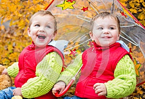 Happy toddler children under an umbrella