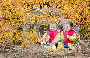 Happy toddler children under an umbrella