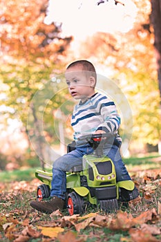 Happy toddler driving a toy truck