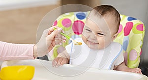 Happy toddler enjoying healthy organic meal in kitchen