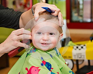 Happy toddler getting his first haircut