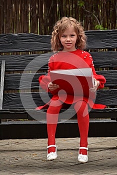 Happy toddler girl with a big red binder