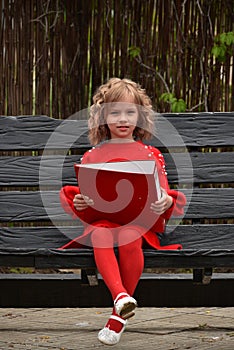 Happy toddler girl with a big red binder
