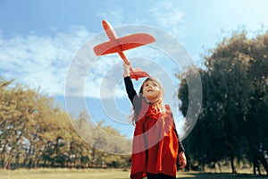 Happy Toddler Girl Holding a Plan Toy up to the Sky