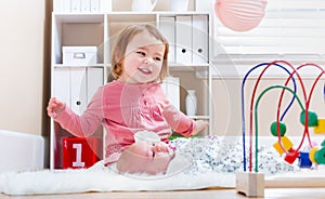 Happy toddler girl playing with her baby sibling