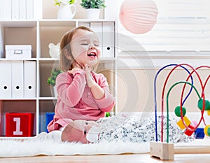 Happy toddler girl playing with her baby sibling