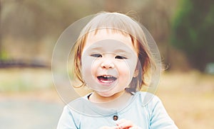 Happy toddler girl playing outside