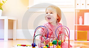 Happy toddler girl playing with toys