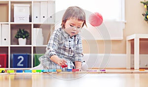 Happy toddler girl playing with toys