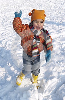 Happy toddler girl is throwing snow balls