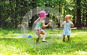 Happy toddler girls playing in a sprinkler