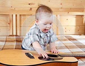 Happy toddler playing guitar