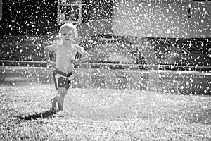 Happy Toddler Playing in the Sprinkler in the Yard