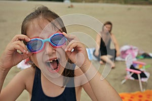 Happy toothless girl on a beach in Romania with goggles