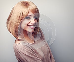 Happy toothy smiling young woman with short blond hair. Toned cl photo