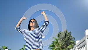 Happy tourist brunette woman smiling jumping having fun at palm background slowmo