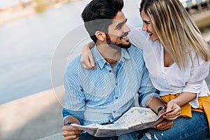 Happy tourist couple with map traveling outdoors