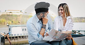 Happy tourist couple with map traveling outdoors