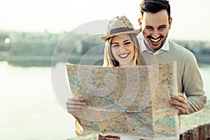 Happy tourist couple with map traveling outdoors