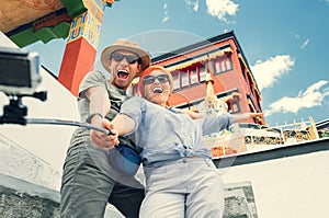 Happy tourist couple take a selfie photo on asian sight background