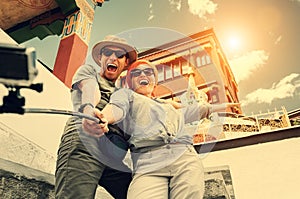 Happy tourist couple take a selfie photo on asian sight background