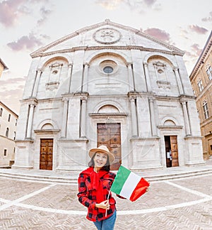 Happy Tourist girl with italian flag travels in Pienza