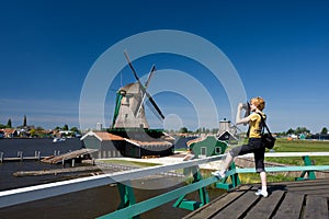 Happy tourist with photo camera and Dutch mill on