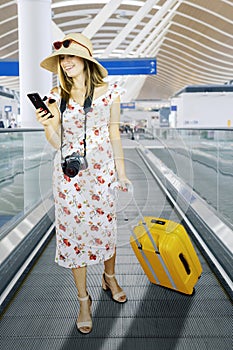 Happy tourist reading message on cellphone in airport
