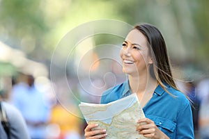 Happy tourist sightseeing holding a guide photo