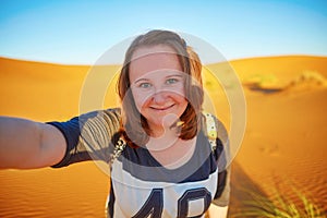 Happy tourist taking selfie in Sahara