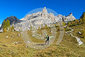 Happy tourist trekker girl in Dolomites mountains in autumn