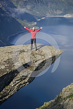 Happy tourist on Troll tongue Trolltunga