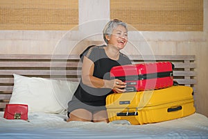 Happy tourist woman arriving in hotel room as an attractive middle aged 40s to 50s lady with grey hair and classy dress smiling