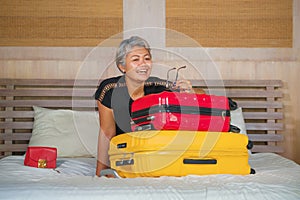 Happy tourist woman arriving in hotel room. Excited and attractive middle aged 40s to 50s lady with grey hair and classy dress