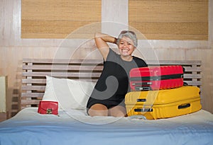 Happy tourist woman arriving in hotel room. Excited and attractive middle aged 40s to 50s lady with grey hair and classy dress