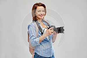 Happy tourist woman with backpack and camera