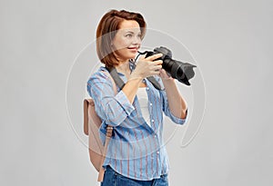 Happy tourist woman with backpack and camera