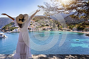 A happy tourist woman enjoys the beautiful view to the little village of Assos