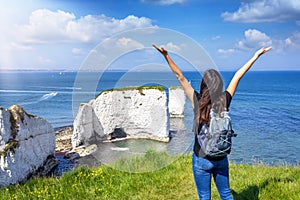 A happy tourist woman enjoys the view of the Old Harry Rocks