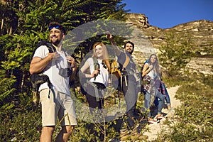 Happy tourists with backpacks travel in the mountains in nature in summer. Tourism. Hiking.