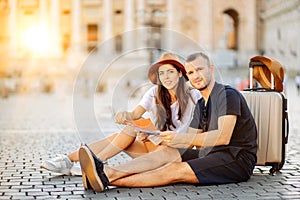 Happy tourists looking at a map and choose a hotel. Couple of tourists on vacation in Rome, Italy. Satisfied tourists