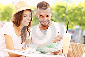 Happy tourists with a map in a cafe