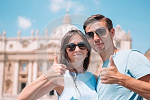 Happy tourists in Rome over St. Peter`s Basilica church in Vatican city background