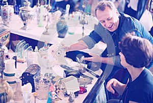 Happy tourists study the range of flea market