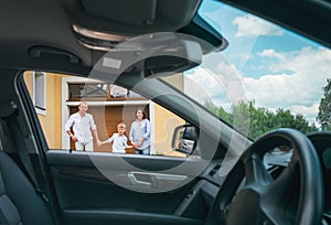 Happy traditional family near their house portrait who bought new car. Inside car view photo