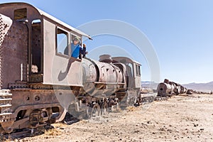 Happy train locomotive driver waving hello, Bolivia trains cemetery