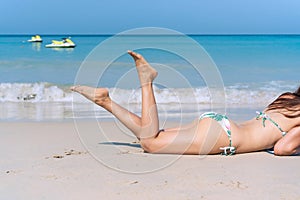 Happy traveler Asian woman in bikini enjoy sunbathing at tropical beach on vacation. Summer on beach concept