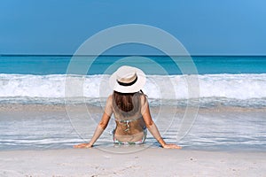 Happy traveler Asian woman in bikini enjoys at tropical beach on vacation. Summer on beach concept